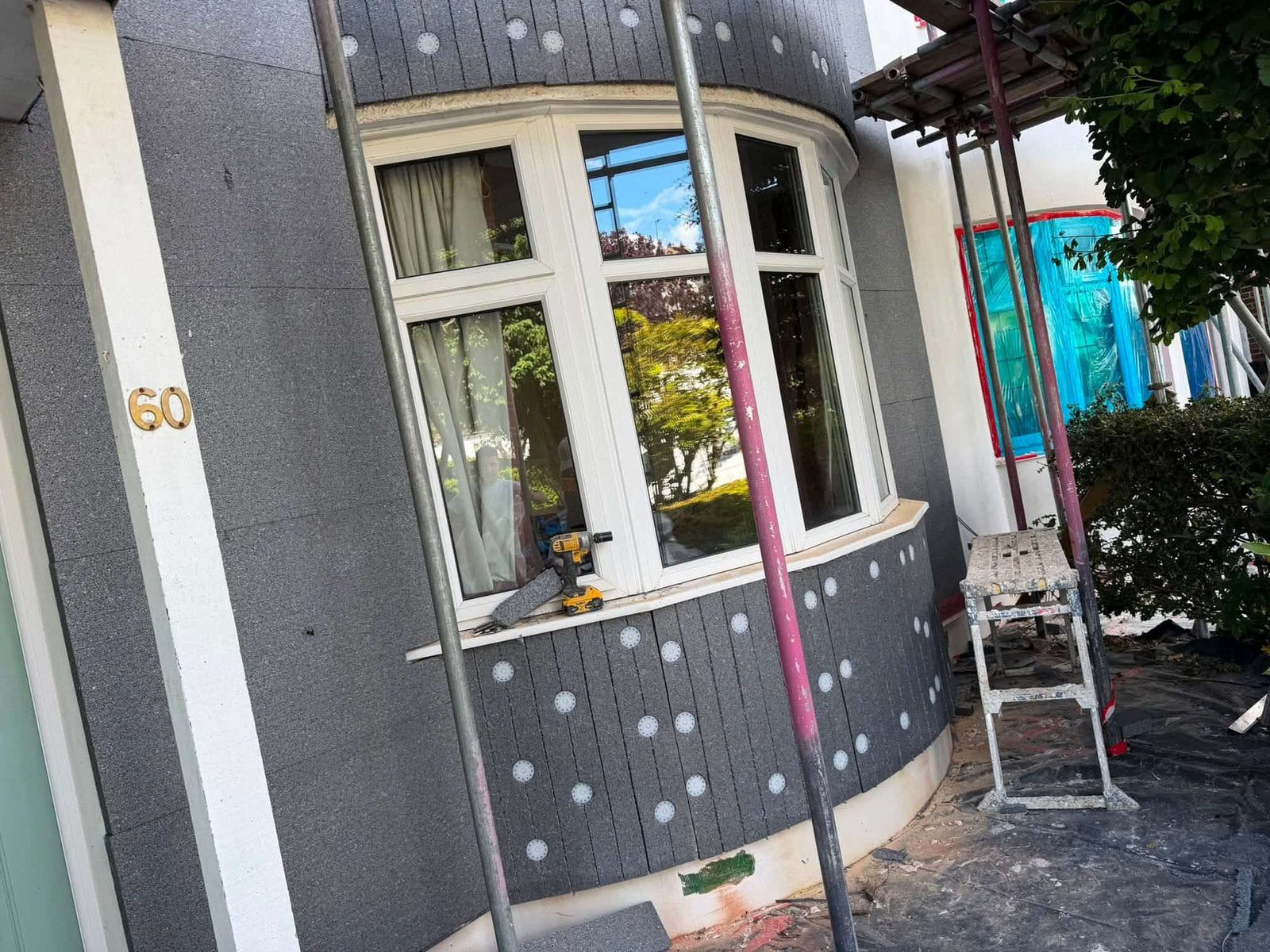 Insulation boards fixed around a curved bay window before rendering