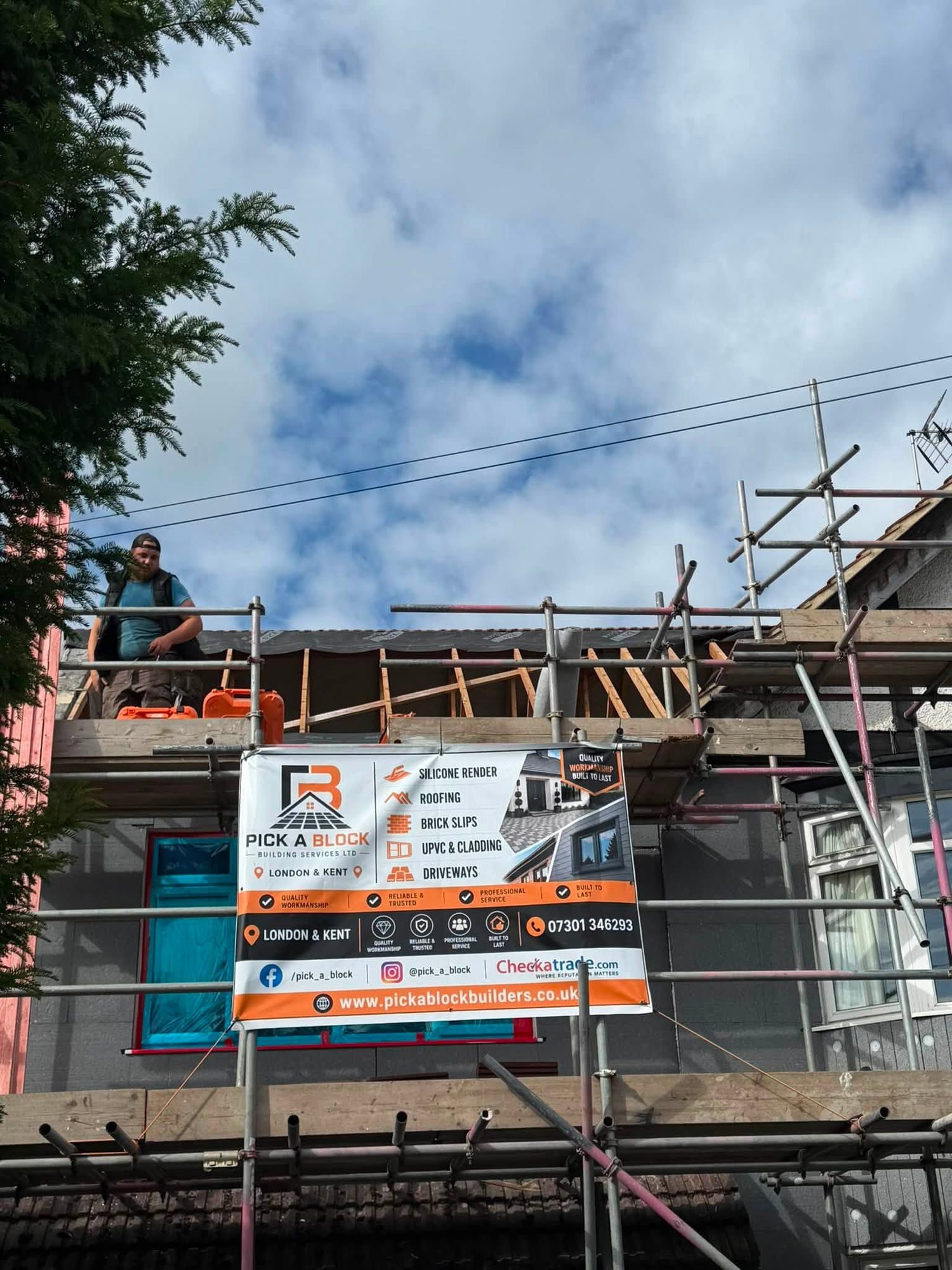 Pick A Block banner on the scaffold while a roof is stripped back to the rafters