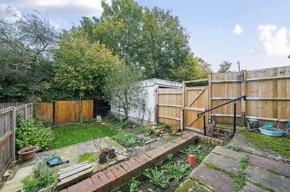 Overgrown garden with rough grass and old paving before the patio was laid