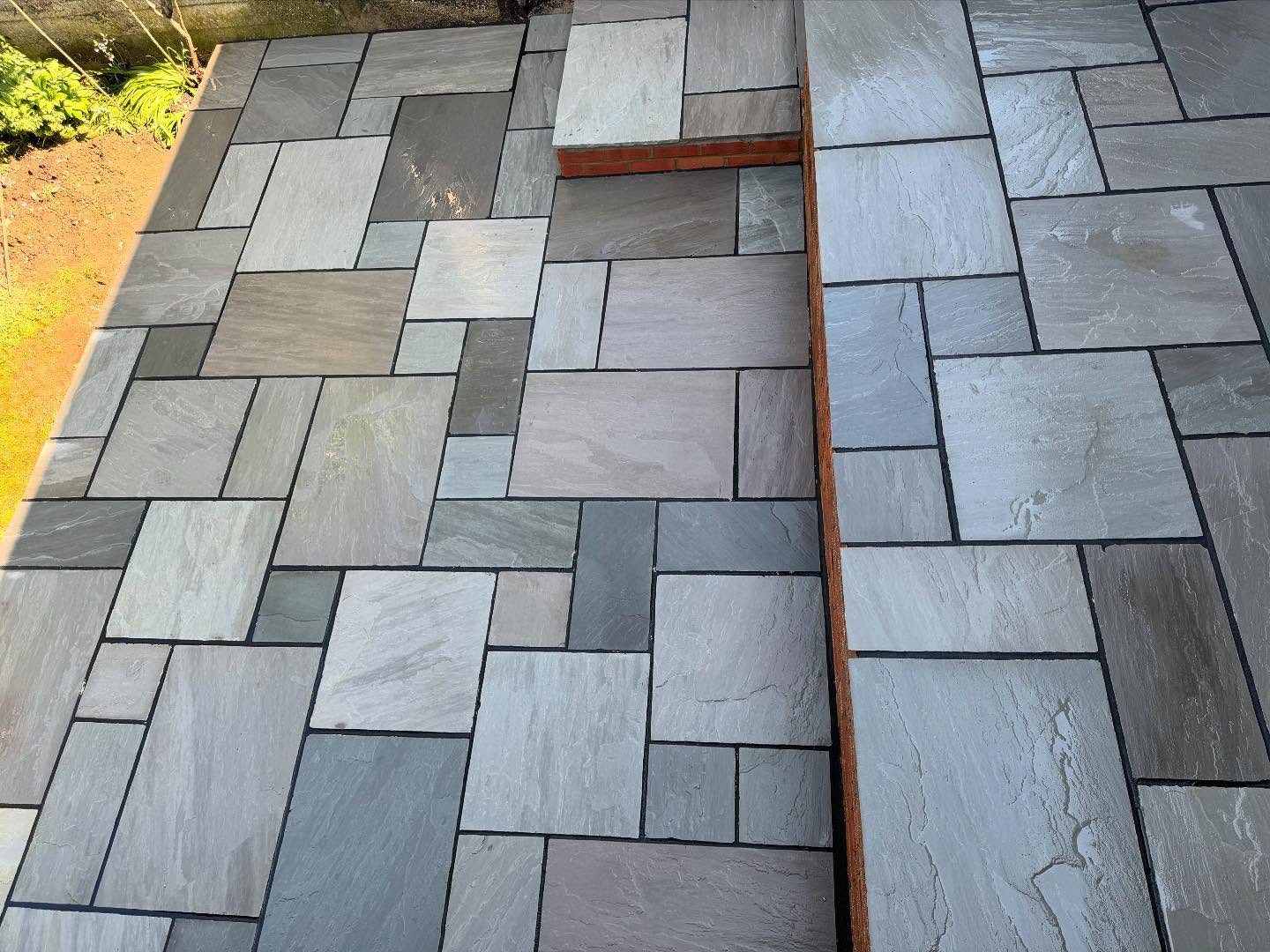 Close view of the sandstone slab pattern and the brick edged step