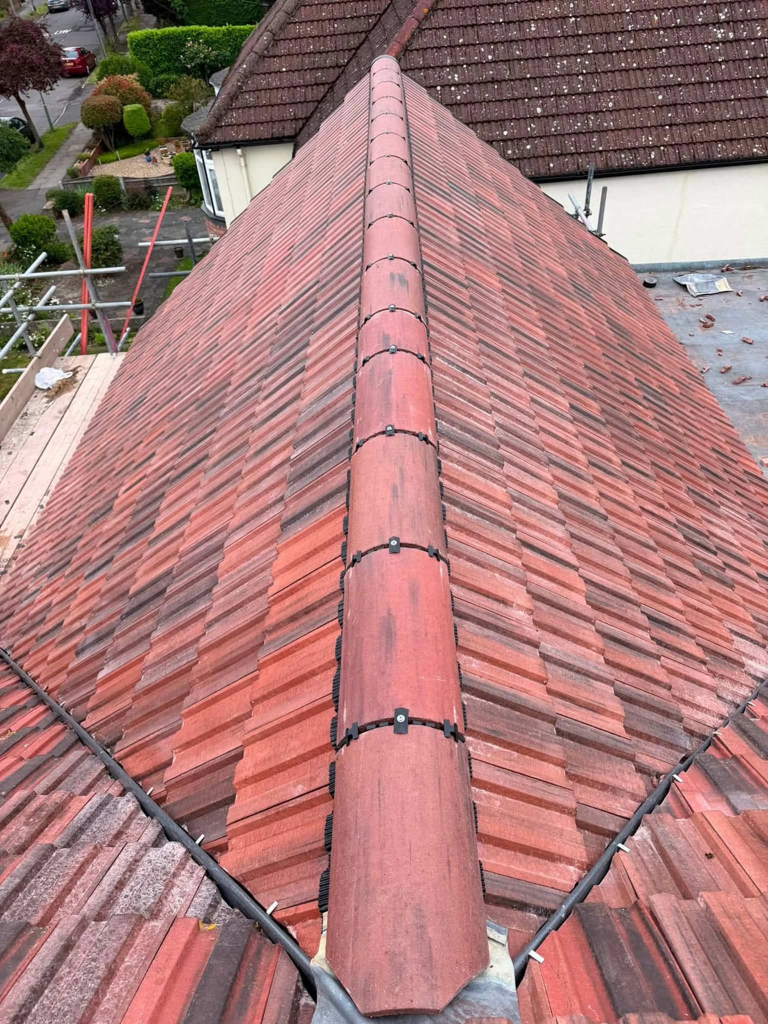 Newly tiled hip roof with fresh ridge tiles and a dry fix ridge system